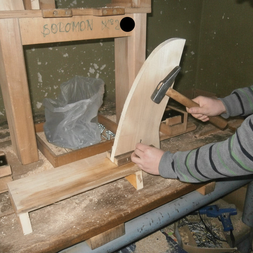 Montage des Holzgrundgestells eines Schaukelpferdes in der Werkstatt.