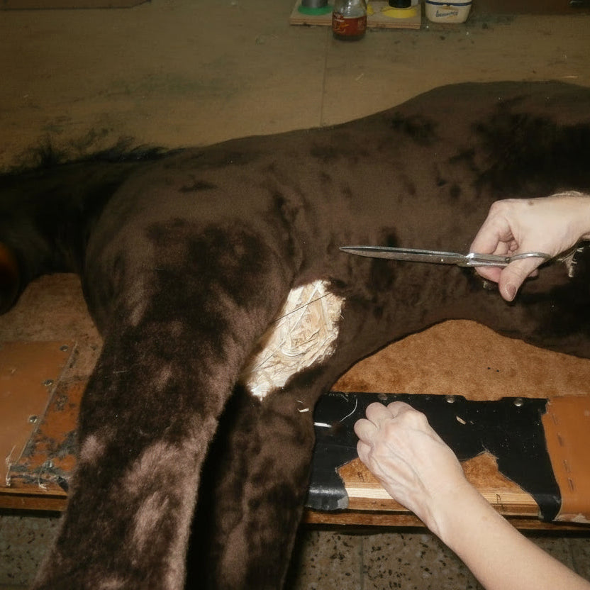 Anbringen des Bezugs an einem Schaukelpferd während der Fertigstellung.